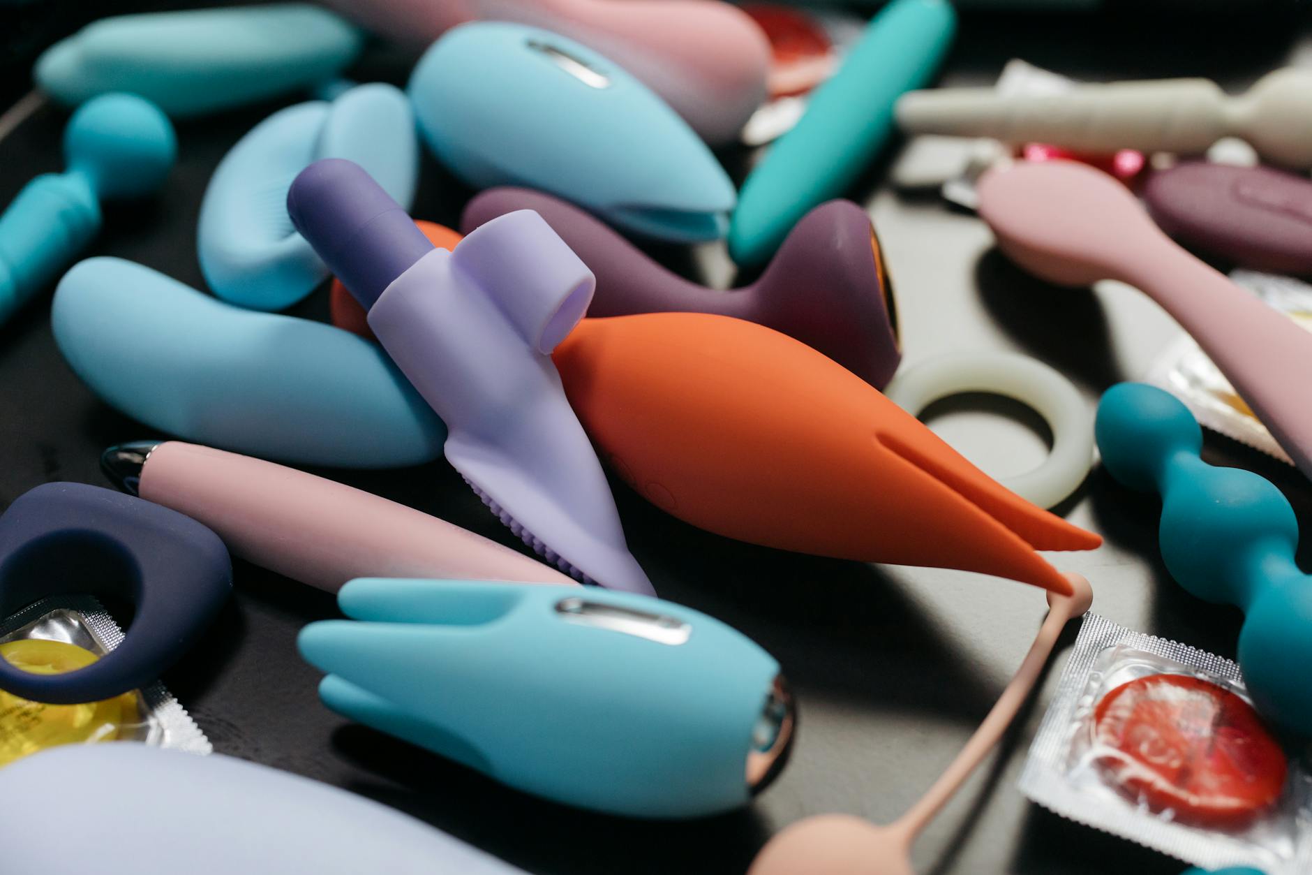 A hand holding a sleek blue vibrator against a purple background, representing sensitive clitoral pleasure and controlled stimulation.