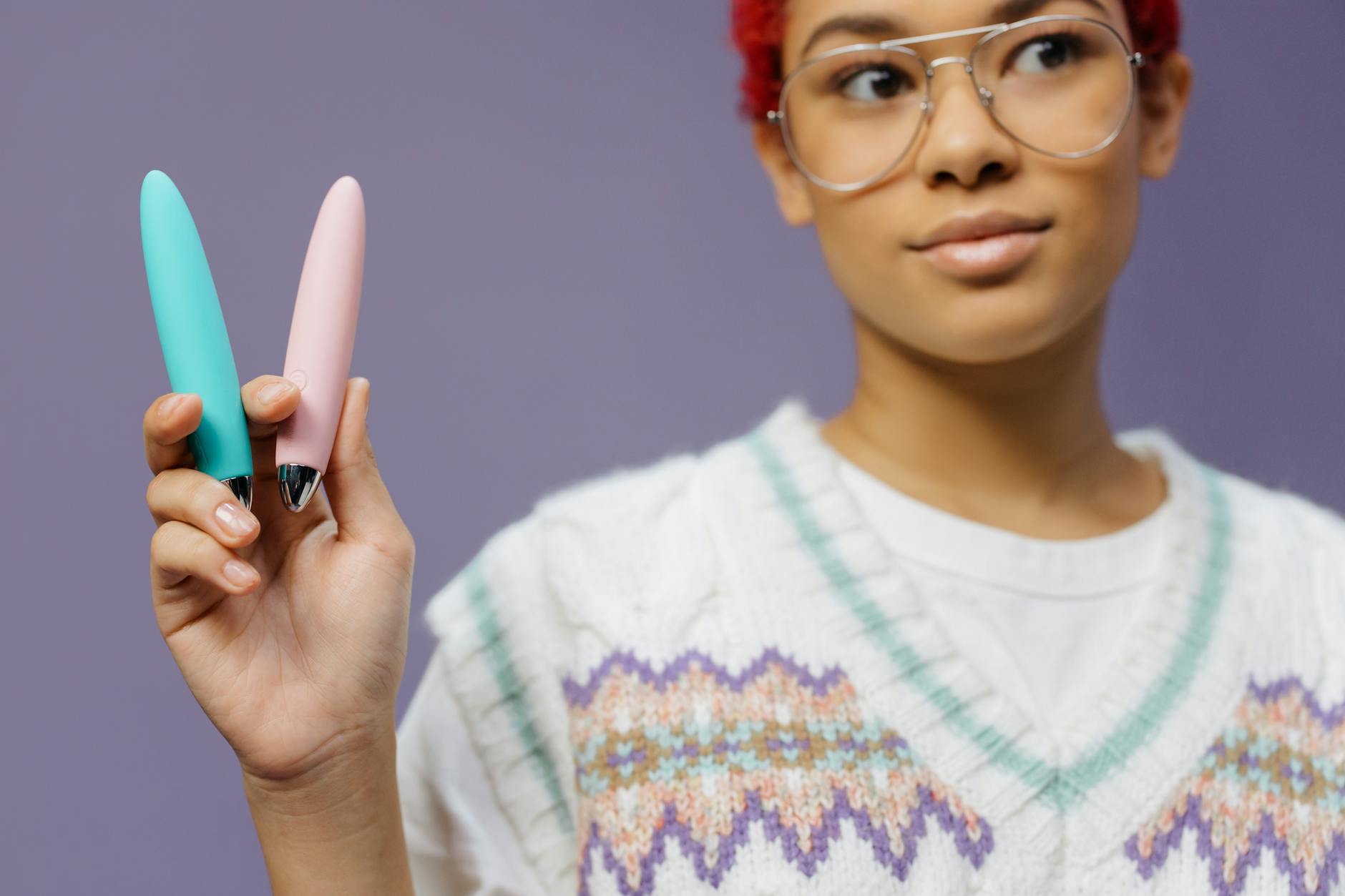 Woman holding colorful vibrators, exploring pleasure and control options