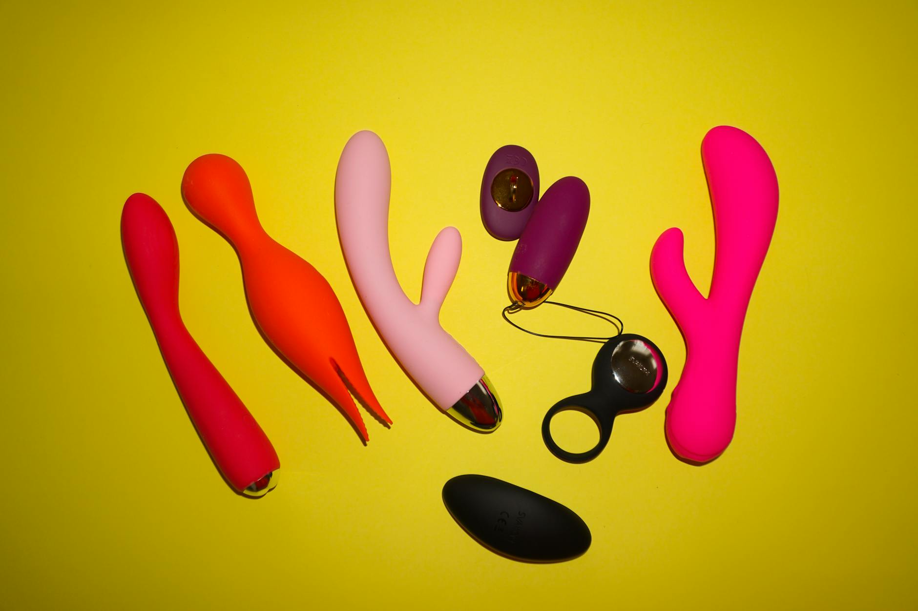 Colorful vibrators on a bright yellow background showcasing variety